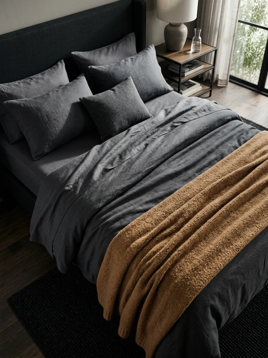 Charcoal Bedding Against Warm Wood Creates a Silent Visual Tension